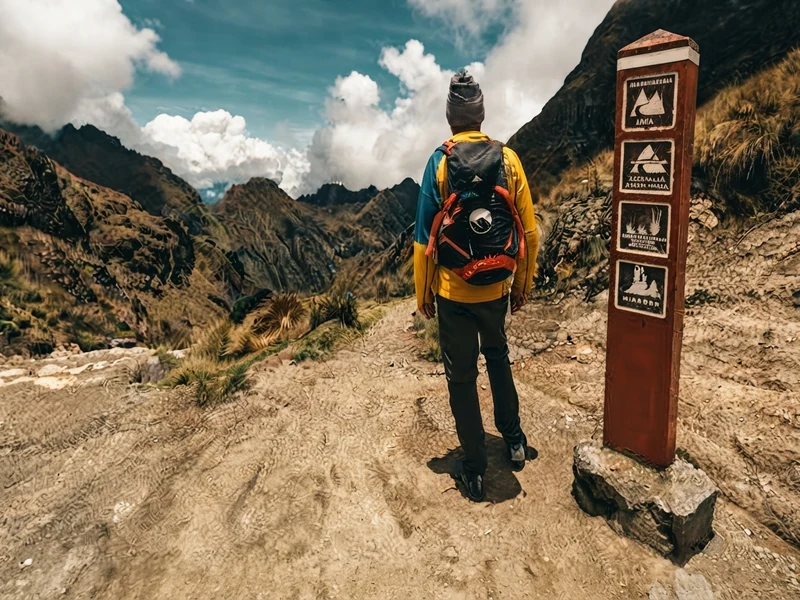 Trekkers posing at the summit sign of Dead Woman's Pass at 4,200 meters
