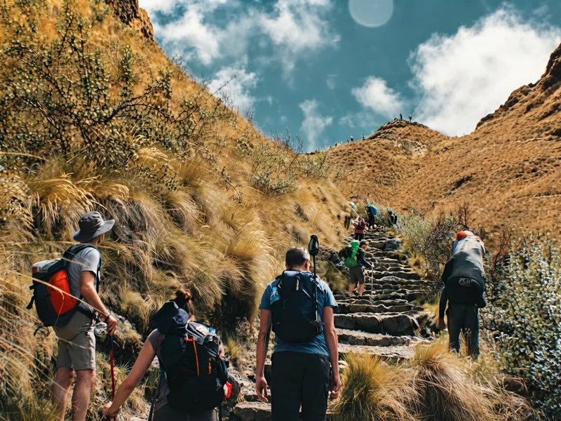 Hikers climbing the steep stone steps toward Warmiwañusca pass