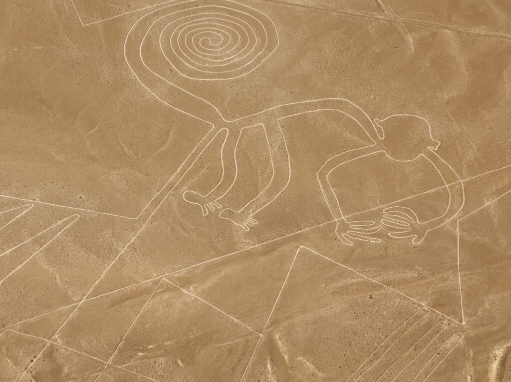 Aerial view of the Monkey geoglyph of the Nazca Lines, with its spiral tail and nine fingers, traced on the desert floor in Ica, Peru