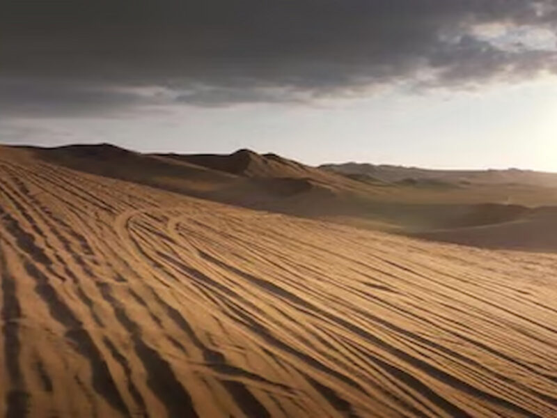 Ica desert dunes at sunset with long shadows across the sand