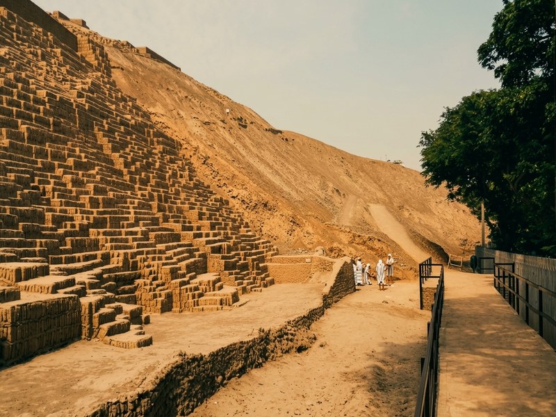 Pirámide precolombina de Huaca Pucllana iluminada con contraste urbano en Miraflores.