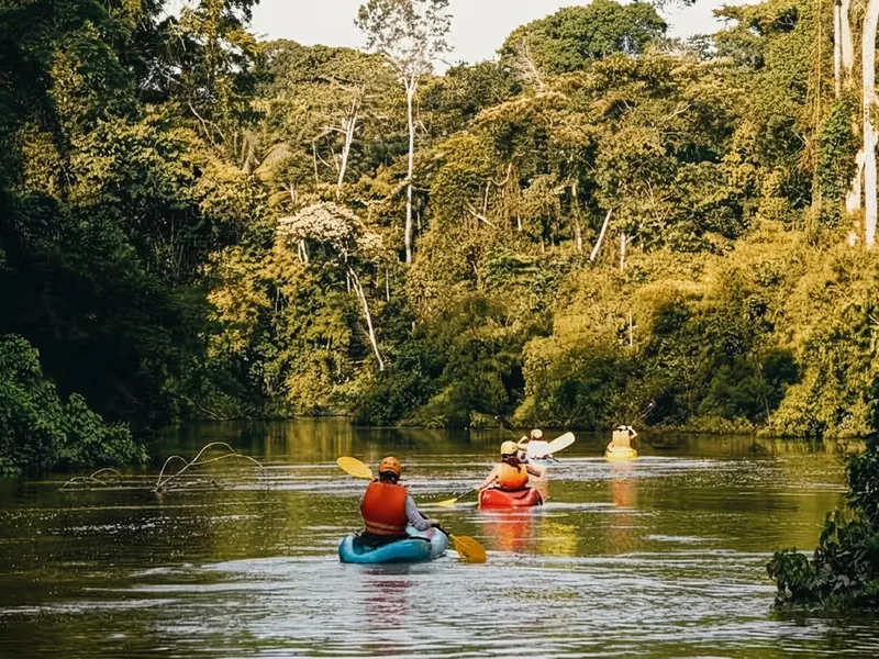 Turistas navegando en kayak por las serenas aguas del río Tambopata en la selva