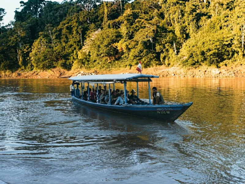Bote con pasajeros navegando por el río amazónico durante las primeras horas de la mañana