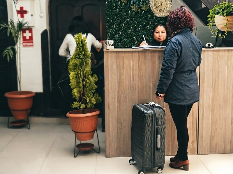 Pasajeros preparándose en el lobby del hotel para el traslado final al aeropuerto.