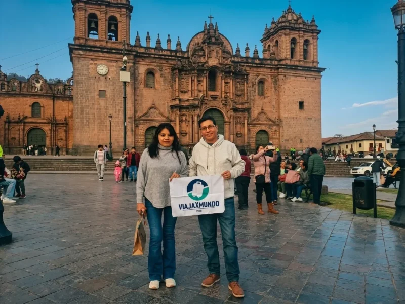 Turistas con bandera de Viajaxmundo Perú frente a la Catedral del Cusco durante su día de aclimatación