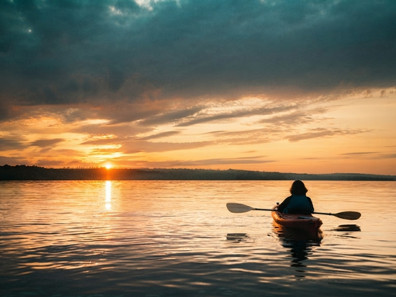 Kayaks navegando en el río Madre de Dios bajo un cielo de atardecer.