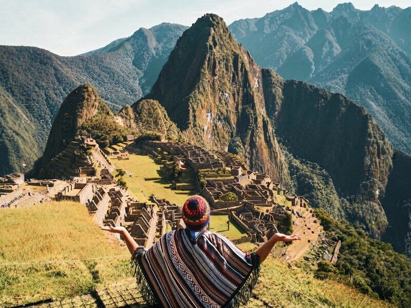Vista clásica de la ciudadela de Machu Picchu rodeada de montañas verdes y neblina.