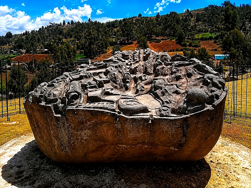 Piedra monolítica tallada de Saywite rodeada de andenes incas en el primer día del trek a Choquequirao