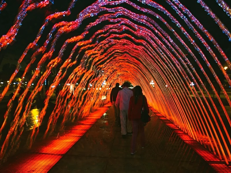 Personas caminando por el túnel de agua interactivo iluminado de colores