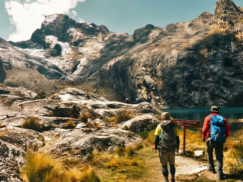 Senderistas escalando el tramo rocoso en la ruta de trekking hacia la Laguna Churup en Huaraz