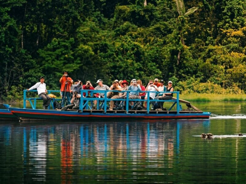 Bote con turistas navegando por el rio Madre de Dios hacia el albergue en Tambopata
