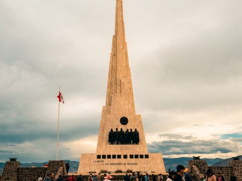 Obelisco del Santuario de la Pampa de Ayacucho junto a la bandera del Perú, monumento a los vencedores de la Batalla de Ayacucho