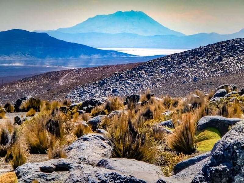Paisaje andino y carretera tradicional atravesando el poblado de Hatunkolla camino a Sillustani en Puno