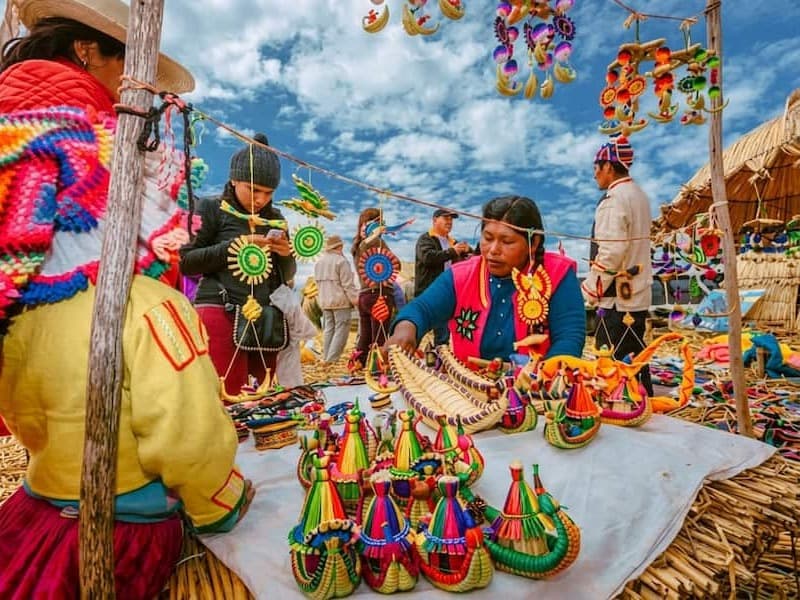 Exposición de artesanías bordadas a mano y tejidos coloridos por comuneras en la Isla Flotante de los Uros