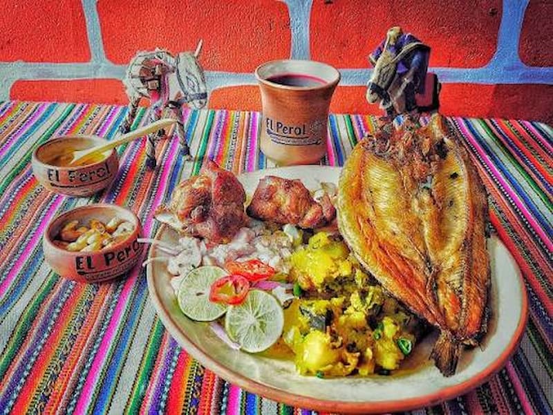 Grupo de viajeros disfrutando de un almuerzo tradicional con trucha fresca preparado por familias locales en Taquile