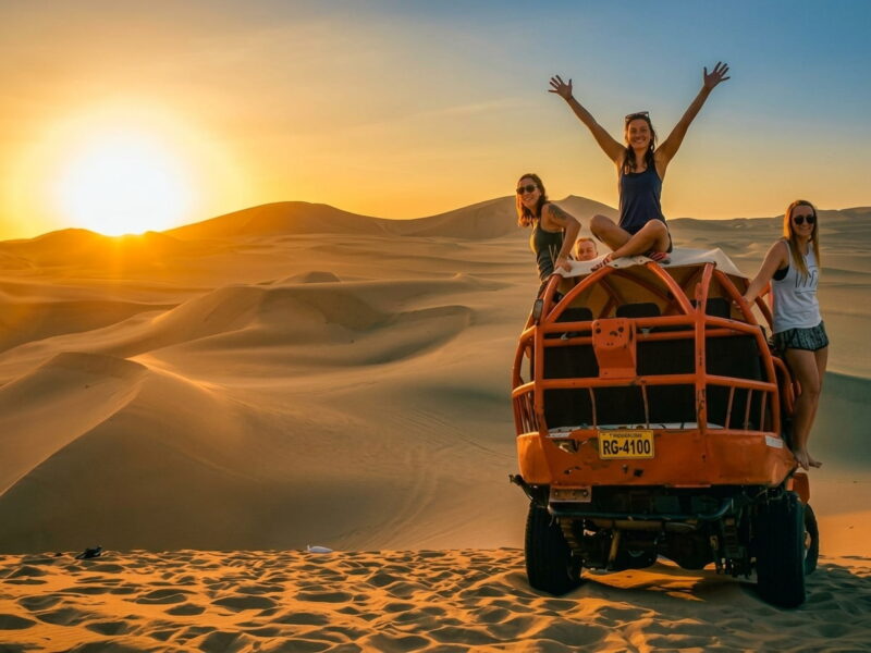 Carro tubular buggy descendiendo por dunas doradas del desierto de Ica cerca de Huacachina.