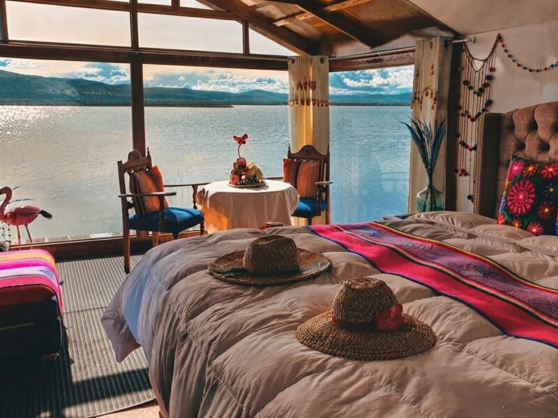 Habitación y terraza de madera sobre isla flotante de totora durante la puesta de sol en el Titicaca.