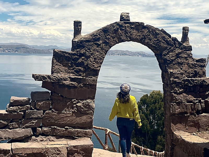 Turistas descendiendo la extensa escalinata de piedra de Taquile hacia la embarcación en el muelle
