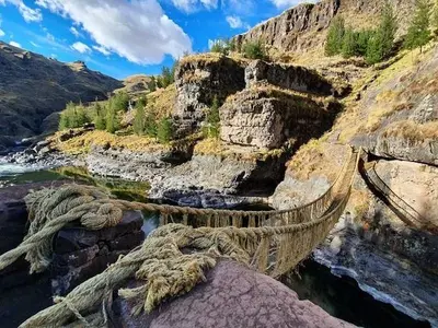 Vista del puente colgante inca Q'eswachaka de sogas de ichu tendido sobre el cañón del río Apurímac en Cusco, Perú