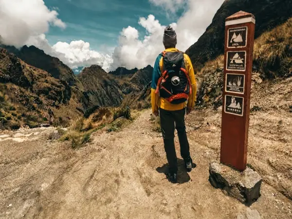 Trekkers celebrating at the summit sign of Dead Woman's Pass, 4,215 m, on the Inca Trail
