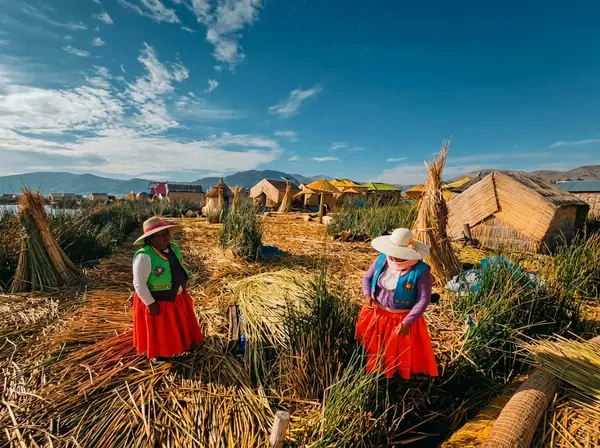 Uros host family showing visitors how a totora reed floating island is built on Lake Titicaca
