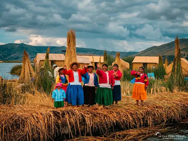 Uros host family waving goodbye to visitors from the Chimu floating island on Lake Titicaca