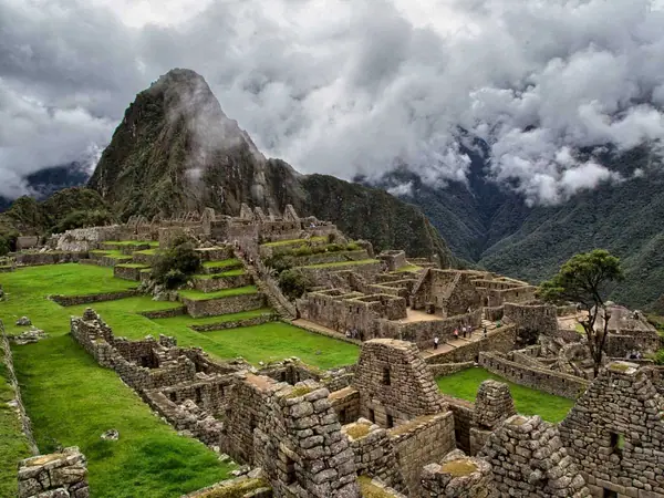 Machu Picchu under heavy rainy-season cloud with mist on the mountains around the citadel