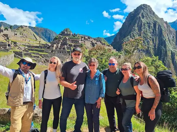 Group of visitors walking the stone streets of Machu Picchu with their guide