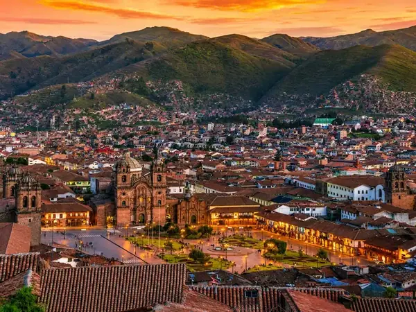 Main Square of Cusco with the illuminated Cathedral and mountains behind