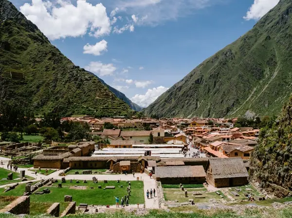 The town of Ollantaytambo seen from the Inca ruins, with its rooftops filling the valley between steep green mountains