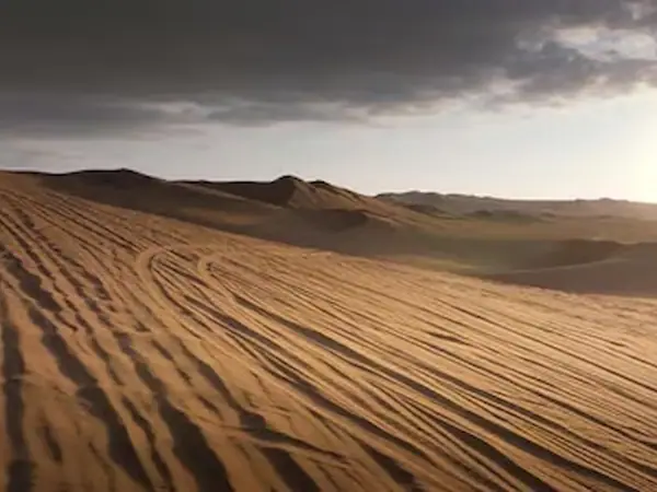 Ica desert dunes at sunset with long shadows across the sand