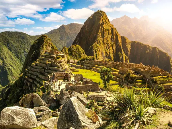 The steep peak of Huayna Picchu rising behind the Machu Picchu citadel, with the smaller hill of Huchuy Picchu to the left