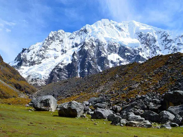 Hikers at the Salkantay Pass facing the snow-capped Salkantay mountain