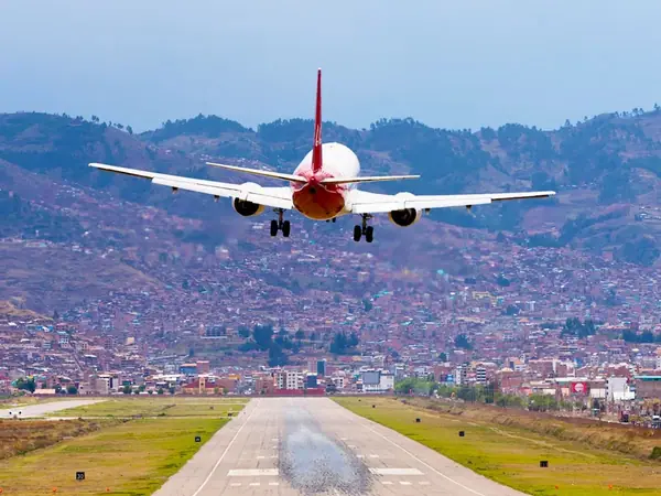 Aircraft on the runway of Alejandro Velasco Astete Airport in Cusco surrounded by mountains
